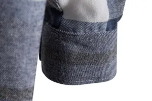 Primo piano della cucitura del polsino su una camicia da uomo a quadri blu e bianchi