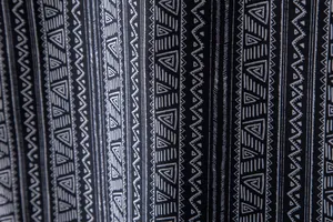 Close-up of the black and white ethnic geometric pattern on the Hawaiian shirt fabric.