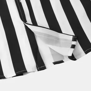 Dettaglio dell'orlo di una camicia a righe bianche e nere con spacco