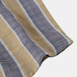 Macro view of striped Hawaiian beach shirt fabric showing detailed texture and stitching.