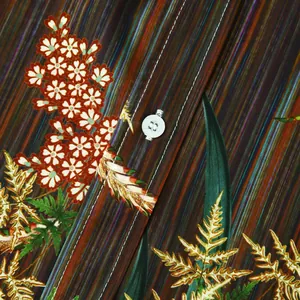 Gros plan du tissu d'une chemise hawaïenne montrant le motif et le bouton