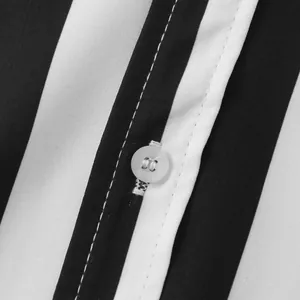 Primo piano di un bottone bianco su una camicia a righe bianche e nere