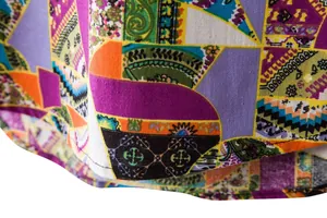 Macro detail of men's linen floral shirt showing vibrant bohemian patchwork pattern