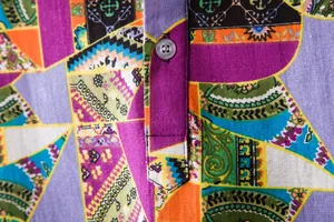 Close-up detail of colorful floral print and button on men's casual linen shirt