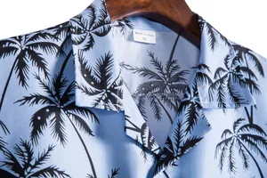 Primer plano de camisa de hombre azul claro con estampados de palmeras negras y etiqueta