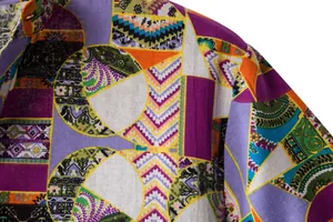 Macro detail of men's colorful patchwork cotton linen shirt with vibrant bohemian print