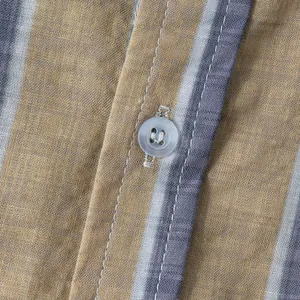 Macro view of vertical striped fabric texture and translucent button on men's shirt
