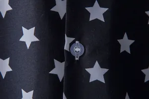 Macro close-up showing white star pattern and translucent button on black men's shirt