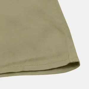 Macro view of olive green cotton fabric texture and neat stitching on men's casual shirt