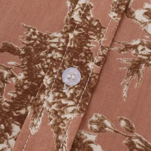 Detailaufnahme des braunen Hawaiihemdes mit Blumenmuster, Textur und Knopf