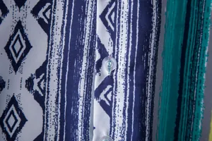 Detailed macro view of the ethnic print fabric and button of a men's Hawaiian shirt