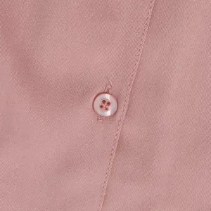 Close-up of pink men's shirt fabric showing twill texture and single button detail