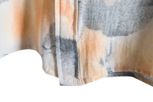 Close-up view of abstract floral print and stitching on men's casual short-sleeve shirt.