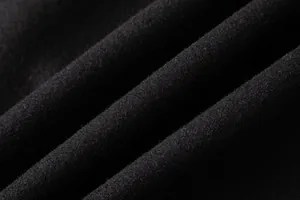 Close-up macro detail of black wool fabric texture for men's winter trench coat.