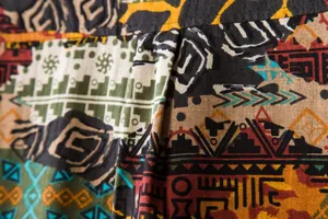 Macro view of the breathable fabric texture and vibrant ethnic pattern of this men's shirt.