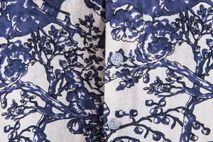 Macro detail of vintage blue floral pattern and buttons on men's Hawaiian linen shirt