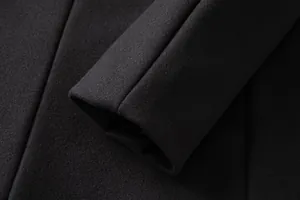 Close-up of the cuff showing the high-quality wool texture of a men's black overcoat
