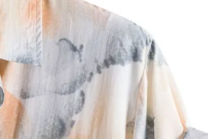 Close-up detail of a men's casual floral shirt showing the abstract ink pattern and texture