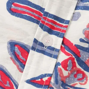Dettaglio camicia da uomo con motivo floreale astratto rosso e blu e bottone.