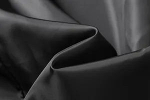 Macro detail of durable black polyester fabric texture for men's winter trench coat