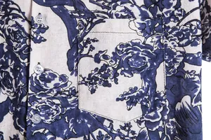 Macro detail shot showing the blue floral pattern and front pocket of a vintage Hawaiian shirt
