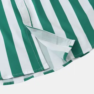 Dettaglio ravvicinato dell'orlo e dello spacco laterale di una camicia hawaiana a righe.