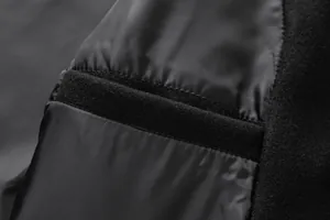 Detailed macro view of the black wool coat interior lining featuring a Velcro strap