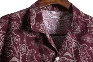 Macro view showing the paisley pattern and collar detail of a maroon casual shirt