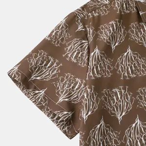 Gros plan détaillé d'une manche de chemise hawaïenne marron avec imprimé floral blanc