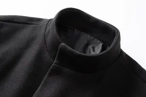 Close-up detail of a men's slim fit black wool coat showing the stand collar and fabric texture