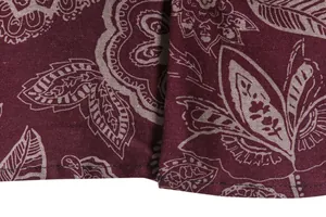 Close-up of burgundy paisley pattern fabric and hem stitching on a men's casual shirt