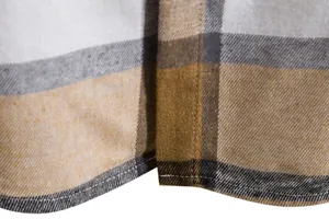 Macro dell'orlo di una camicia a quadri gialla e grigia con doppie cuciture