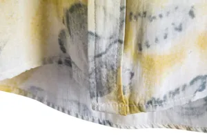 Detailed view of yellow abstract print and hem stitching on men's casual shirt