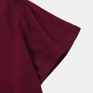 Close-up detail of burgundy men's short sleeve shirt showing fabric texture and stitching