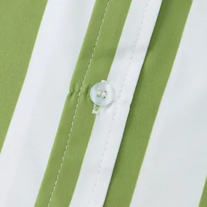 Dettaglio ravvicinato di bottone e tessuto a righe verdi su camicia hawaiana da uomo.