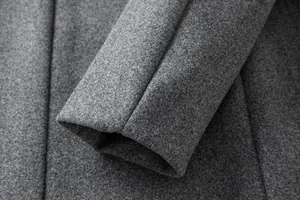 Detailed close-up showing the grey wool fabric texture and cuff stitching of a men's coat