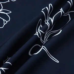 Détail du tissu de chemise hawaïenne bleu marine avec motifs floraux blancs