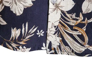Macro view showing the intricate floral print and linen texture of a men's Hawaiian shirt.