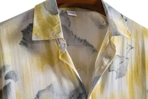 Close-up of yellow and gray abstract floral print on men's casual short-sleeve shirt