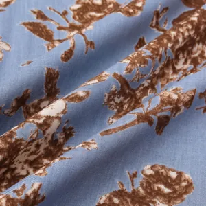 Detailaufnahme eines blauen Hawaiihemd-Stoffs mit braunem Blumendruck und Webstruktur.