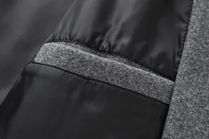 Macro detail of men's grey wool coat showing smooth black lining and high-quality seam work