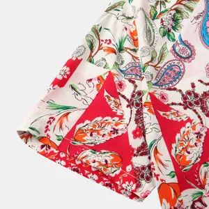 Close-up detail of vibrant paisley and floral print on white men's short sleeve shirt sleeve