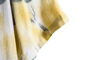 Macro detail of men's short sleeve cuff with yellow tie-dye print and stitching