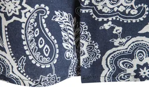 Close-up of navy blue paisley print fabric and stitching on a men's shirt.