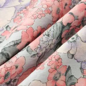 Primo piano della fantasia floreale rosa e viola sul tessuto di una camicia da uomo estiva