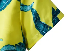 Close-up of tropical leaf print and stitching on yellow Hawaiian shirt sleeve