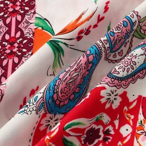 Detailed macro view of vibrant multi-colored paisley and floral print fabric for summer shirts.