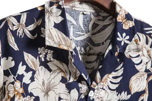 Detail showing the tropical floral pattern and fabric texture of a men's Hawaiian shirt
