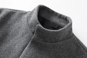 Close-up detail of a grey wool coat collar showing fabric texture and lining