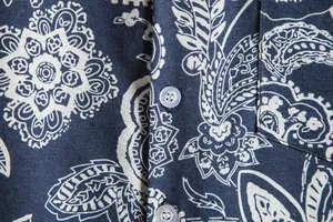 Macro detail of navy blue paisley print and fabric texture on men's shirt